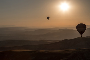 Balloons over mointains and rocks in cappadocia 