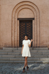 Fototapeta na wymiar flirting indian lady in white dress against ancient building