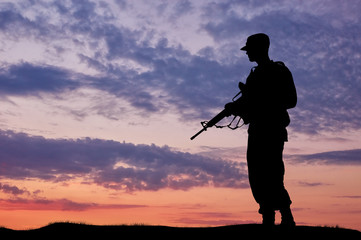 Fototapeta na wymiar Silhouette of soldier with a gun