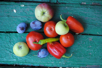 Vegetables and fruits on the green backround (tomatos, paper, apples, grapes, plums)