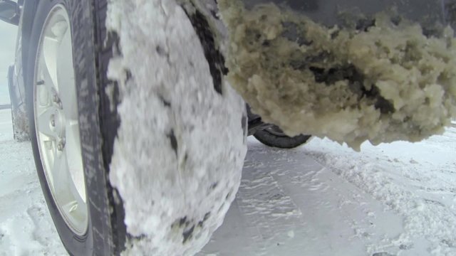 Detail of a rear tire while driving in the snow.	