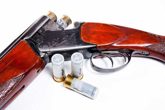 Hunting shotgun and ammunition on white background.