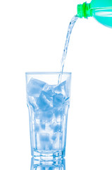 Water pouring from bottle into the glass, isolated on white