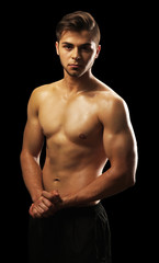 Fototapeta premium Muscle young man on dark background