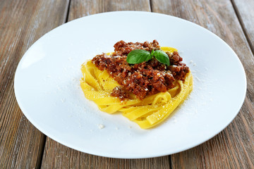 Pasta Bolognese with parmesan and basil on plate close up