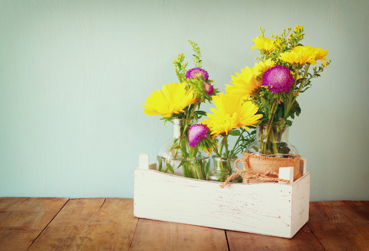 summer bouquet of flowers on the wooden table with mint background