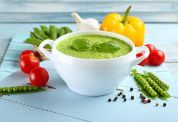 Tasty peas soup and vegetables on table close up
