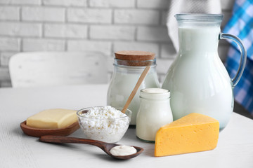 Dairy products on wooden table, on brick wall background