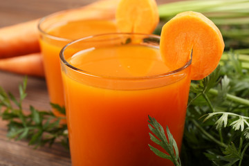 Glasses of carrot juice with vegetables on table close up