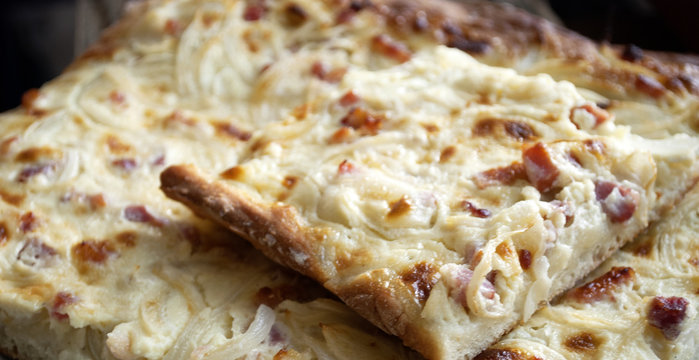 Hausgemachter Els&auml;sser Flammkuchen, Zwiebelkuchen auf altem Treibholz / Holz Brett 