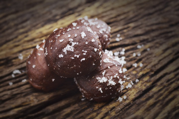 Small chocolate doughnuts on old wooden background