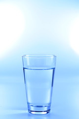 Glass of water on light background