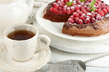 Piece of cake with chocolate Glaze and raspberries on color wooden background