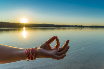 Mudra-Handstellung beim Yoga für Konzentration im Sonnenuntergang