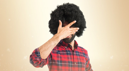 Afro man covering his face