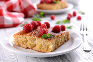 Fresh pie with raspberry in white plate on wooden table, closeup