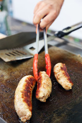 Sausages cooking in frying pan close up