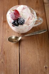 Delicious ice cream with fresh frozen berries, on rustic wooden background