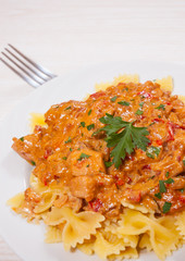 meat in a sauce with farfalle pasta