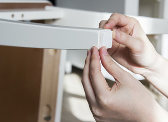 Young woman are sticking floor care pad at chair legs © ArtBackground