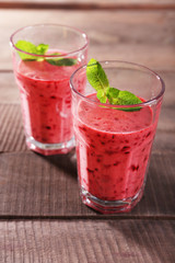 Glasses of berry smoothie on wooden background
