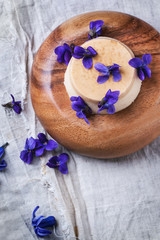 Caramel pannacotta with violet flowers