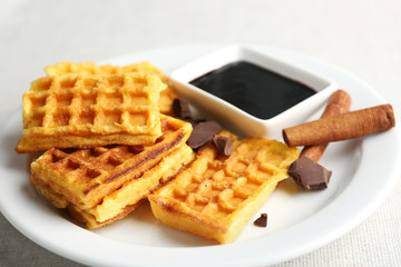 Sweet homemade waffles on plate, on light background