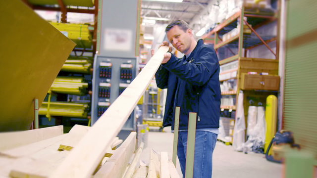 A man picks out lumber at a big box hardware store