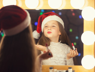 Young girl in red Santas hat with lipstick