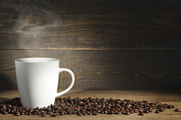 Tasse à café et grains de café sur fond en bois.