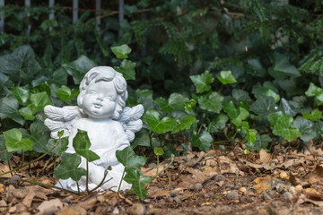 Engel Figur sitz zwischen Efeu Blättern
