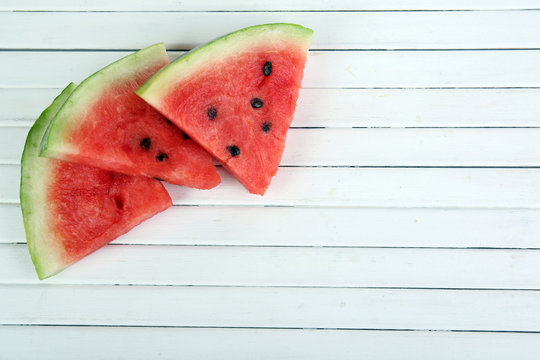 Slices of ripe watermelon on wooden background