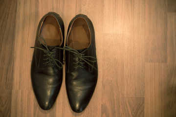 A pair of brown leather shoes on wooden floor - vintage style effect picture