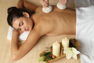 Obraz na płótnie Canvas Young woman enjoying back massage in beauty spa salon