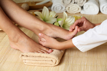 Obraz na płótnie Canvas Masseur making feet massage in spa salon