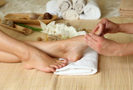 Masseur making feet massage in spa salon