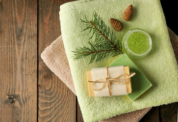 Obraz na płótnie Canvas Handmade soap and cream with pine extract and spa treatments on wooden background
