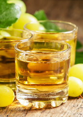 Light grape juice on wooden  background, selective focus