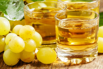 Light grape juice on wooden  background, selective focus