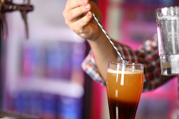 Bartender is pouring beer into glass