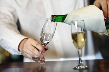 Portrait of handsome bartender with champagne bottle