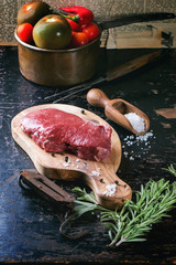 Raw steak with herbs and pepper