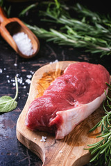 Raw steak with herbs and pepper