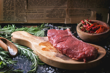 Raw steak with herbs and pepper