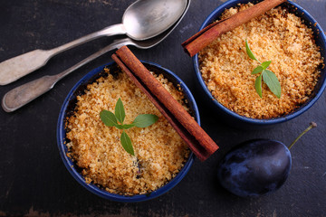 crumble with plums and cinnamon on a black background
