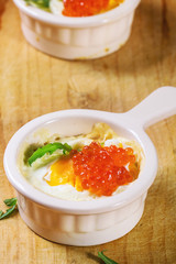 Baked eggs with red caviar