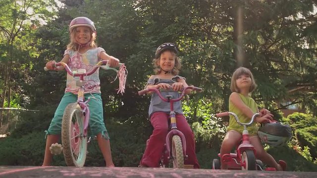 Three sisters sitting on their bikes and smiling
