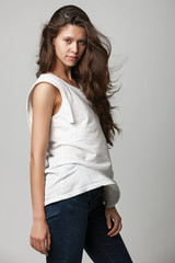 Portrait of a fashionable young brunette beauty in white top.