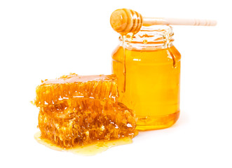 Sweet honeycomb and jar of honey with stick