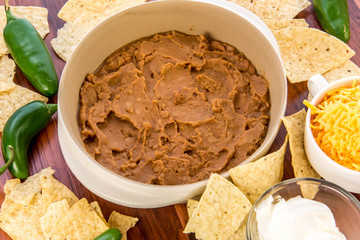 preparation of bean dip with jalapenos, sour cream and cheddar c